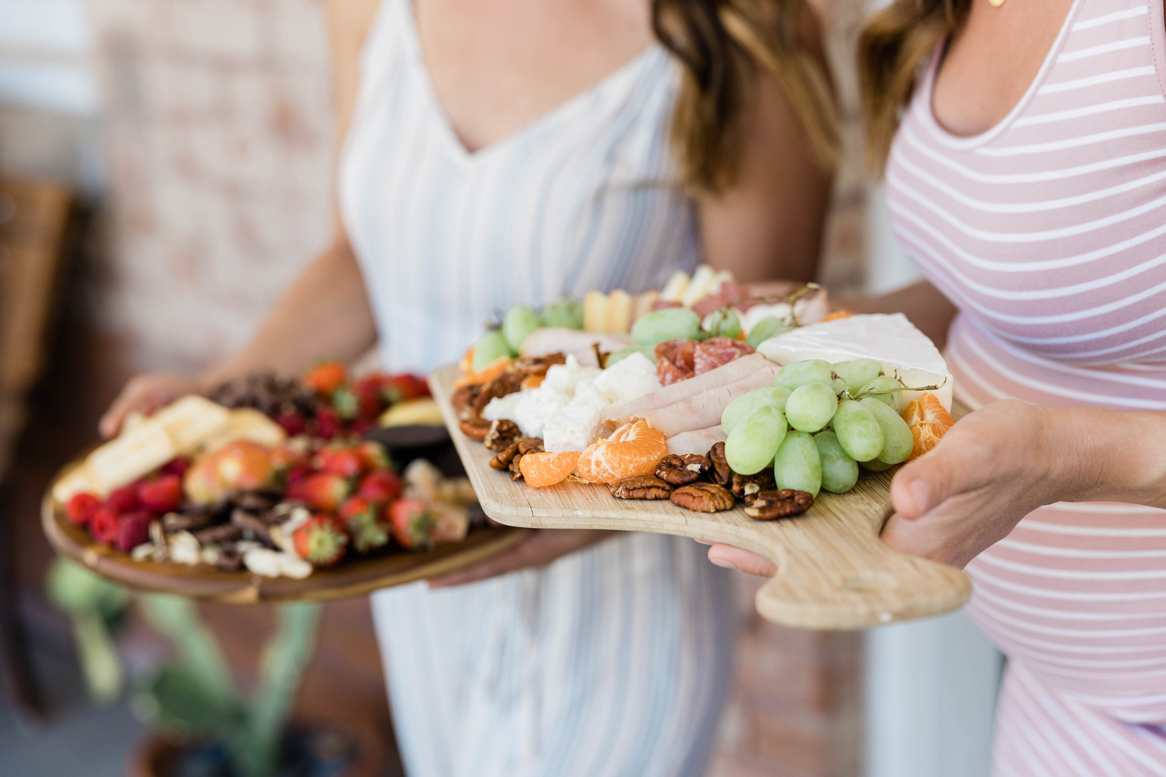 Two Women Holding Charcuterie Boards